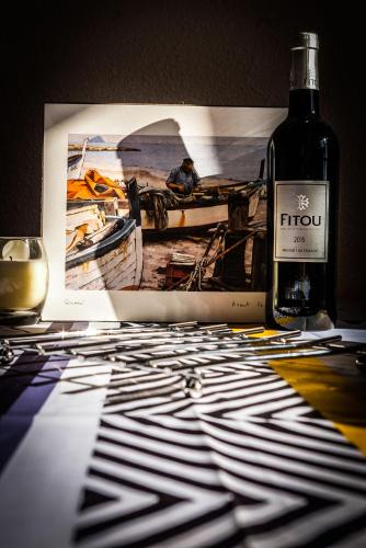 - une bouteille de vin assise sur une table avec une photo dans l'établissement Appartement St Pierre la mer, à Saint Pierre La Mer