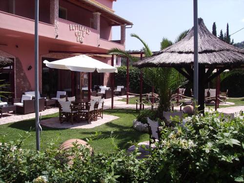 a restaurant with tables and chairs and an umbrella at Kostas Apartments & studios in Agios Georgios Pagon