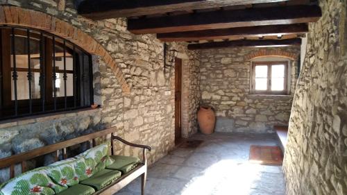 a room with a bench in a stone building at Villa La Nussa in Capolona