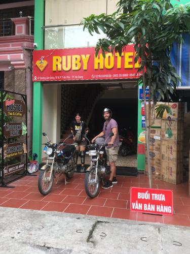 two men standing in a shop with their motorcycles at Ruby Hostel Hà Giang in Ha Giang