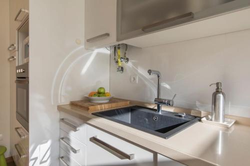 a kitchen with a sink and a bowl of fruit at 2 Bedroom Belem Wonder by LovelyStay in Lisbon