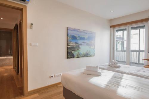 a white bedroom with a bed with towels on it at 2 Bedroom Belem Wonder by LovelyStay in Lisbon