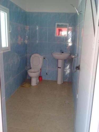a bathroom with a toilet and a sink at Hôtel La Corniche in Akhfennirr