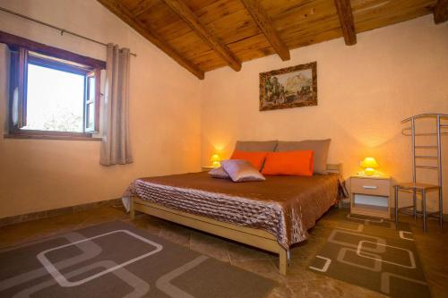a bedroom with a bed with two lamps and a window at Holiday House Legovic in Nova Vas