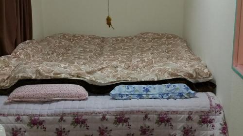 a bed with two pillows on top of it at "Cherry House" is Direct to Narita,Haneda AP, Disney, Asakusa, Skytree Tower, Tokyo in Matsudo