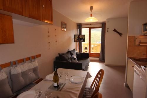 un salon avec une table et un canapé dans l'établissement Cimes De Caron Appartements VTI, à Val Thorens