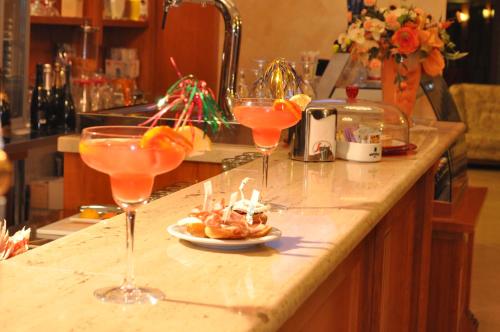 three wine glasses on a counter with a plate of food at Domus Hotel in Bagnoli del Trigno