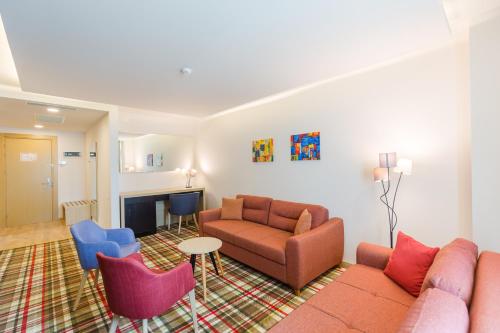 a living room with a couch and a chair at Best Western Premier Batumi in Batumi