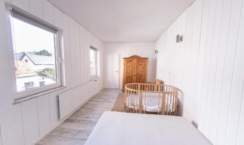 a white room with a bed and a window at Lotsenkoje in Cuxhaven