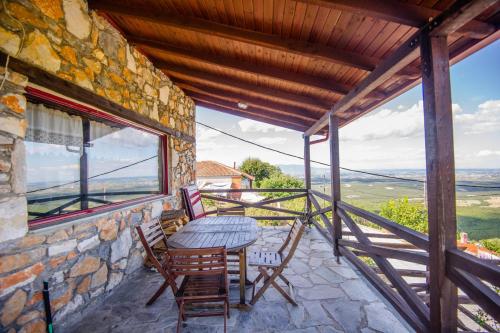 a table and chairs on the balcony of a house at Stonehouse 2 Bedroom Chalet on Olympus Amazing View in Pétra