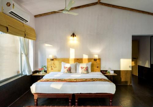 a bedroom with a large bed with a wooden headboard at The Riverwood Forest Retreat Pench in Khawāsa
