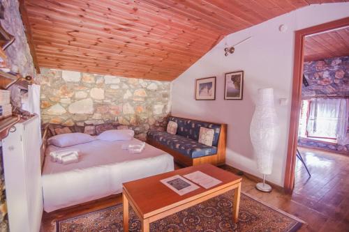 a bedroom with a bed and a table and a couch at Stonehouse 2 Bedroom Chalet on Olympus Amazing View in Pétra