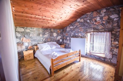 a bedroom with a bed and a stone wall at Stonehouse 2 Bedroom Chalet on Olympus Amazing View in Pétra