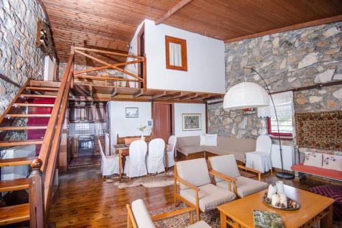 a dining room and living room with a staircase in a house at Stonehouse 2 Bedroom Chalet on Olympus Amazing View in Pétra