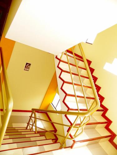 a staircase with a yellow and red stair case at Hotel Villa Rita Chiclayo in Chiclayo