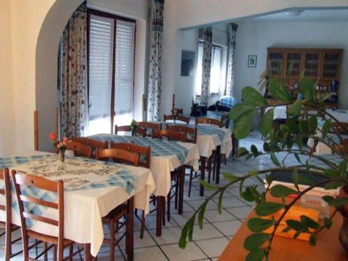 un comedor con mesas, sillas y plantas en hotelverbania, en Sabaudia