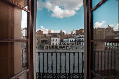 una ventana abierta con vistas a la ciudad en Apartamentos Soho Boutique Plaza Mayor Caceres en Cáceres