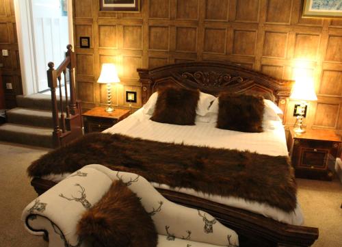 a bedroom with a large bed with a fur blanket at The Lion Hotel in Buckden