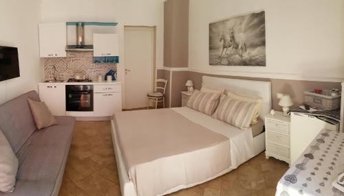 Cet appartement comprend une chambre avec un grand lit blanc et une cuisine. dans l'établissement Il Casale dei Principi, à Lecce