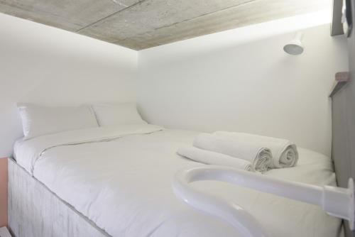 a white bed with a sink in a room at room2 Southampton Hometel in Southampton