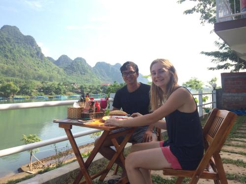 a man and a woman sitting at a picnic table at Carambola Bungalow in Phong Nha