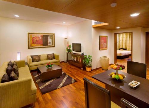 a living room with a couch and a table at Kenilworth Hotel, Kolkata in Kolkata