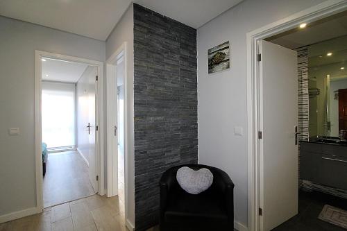 マトジニョシュにあるSweet Home CRの黒い椅子とレンガの壁が備わる客室です。