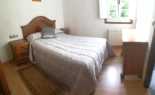 a bedroom with a bed and a wooden floor at Hostal La Casilla in Guitiriz
