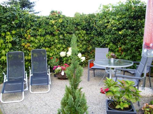 a patio with chairs and a table and some plants at Appartement Muschelkoje in Ostseebad Karlshagen