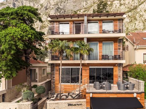 a house with a palm tree in front of it at Hotel Forza Mare in Kotor