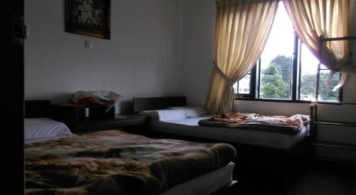 En eller flere senge i et værelse på Nuwara Eliya Homestay