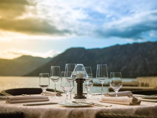 a table with wine glasses and napkins on it at Hotel Forza Mare in Kotor