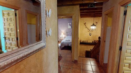 a hallway with a room with a bed and a mirror at La Majada Palentina in Villanueva de Arriba