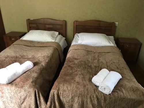 two beds with towels on them in a bedroom at Guesthouse Chela in Mestia