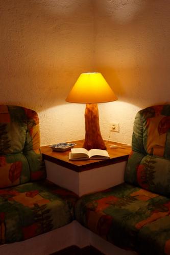 a lamp on a table next to a couch with a book at Casa Rural Mas de Sant Pau - Turistrat. in Albocácer