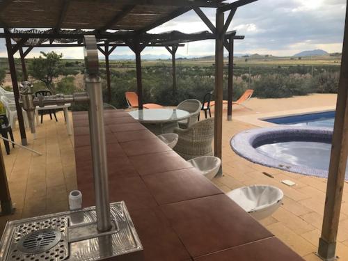 une terrasse avec un bain à remous, une table et des chaises dans l'établissement Cortijo de los Castellanos, à Las Ventanas