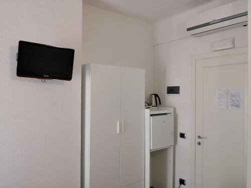 a room with a refrigerator and a tv on the wall at Albergo Al Carugio in Monterosso al Mare