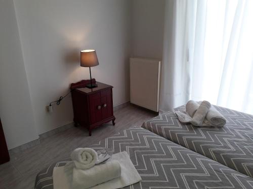 a bedroom with a bed with towels on it at Kalos Gialos Sunrise Apartment in Porto Rafti