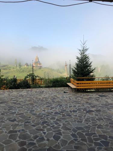 a park with a bench and a pagoda in the background at Privatna Sadiba Chalet in Oryavchyk
