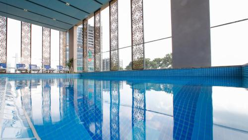 ホーチミン・シティにあるOrchids Saigon Hotelの青い水の建物内のスイミングプール