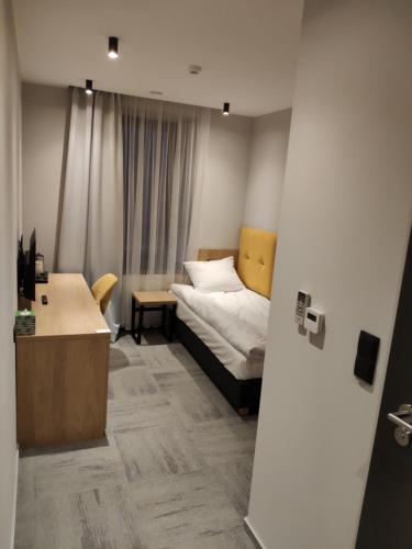 1 dormitorio con 1 cama y escritorio en una habitación en H33 Apartamenty en Bytom