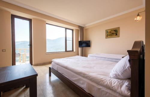 a bedroom with a bed and a large window at Lastiver Resort in Yenokavan