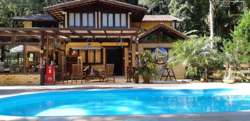 a house with a swimming pool in front of a house at Arara Azul in Nova Friburgo