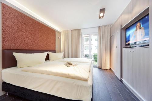Residenz Margarete by Callsen في بينز: غرفة نوم بسرير كبير وتلفزيون بشاشة مسطحة