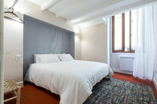 une chambre avec un grand lit blanc et une fenêtre dans l'établissement Prefecture Duplex - Old Town, à Nice
