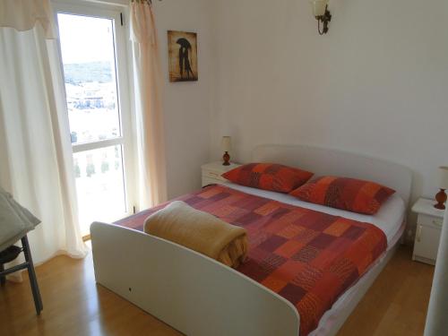a bedroom with a bed and a large window at Radojka in Primošten