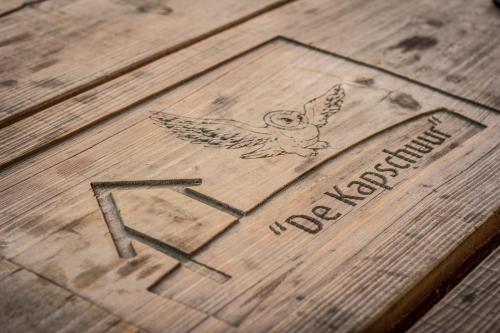 a drawing of an owl on top of a wooden table at De Kapschuur in Stadskanaal