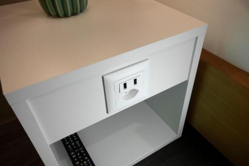 a white counter with an electrical outlet on it at Hotel Birsighof Basel City Center in Basel