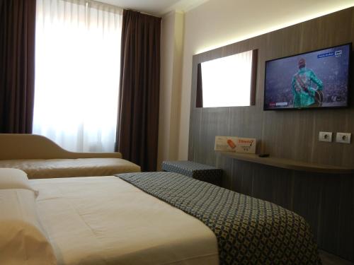 a hotel room with a bed and a flat screen tv at Delle Nazioni Milan Hotel in Milan