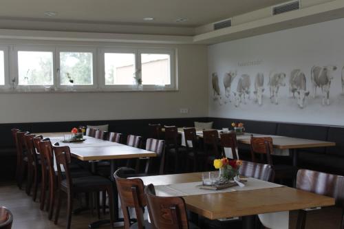 a dining room with tables and chairs and windows at Gasthaus Hirsch in Ersingen